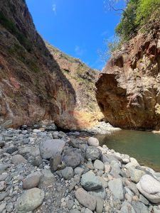 Rocky canyon with towering cliffs under a vivid blue sky