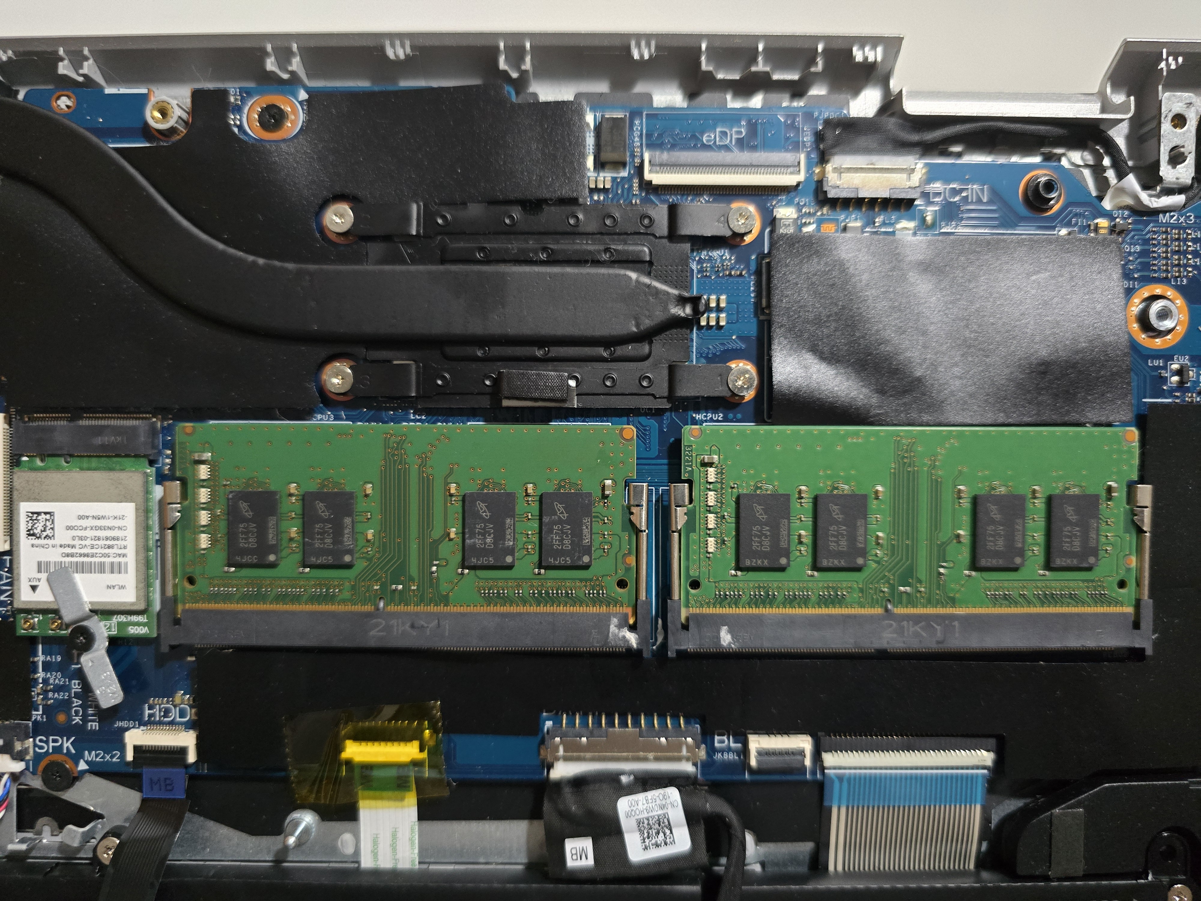 Two SODIMM RAM modules installed on a laptop motherboard with nearby cooling components.