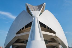 Low-angle view of the futuristic Palau de les Arts Reina Sofía against a clear blue sky.