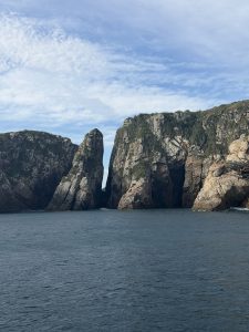 
A dramatic coastal scene featuring two towering rock formations that rise from the ocean.