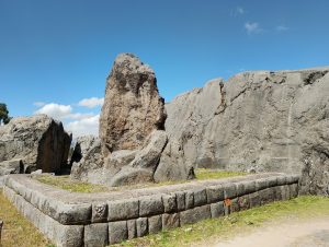 Large stone monolith at Qenqo, an Inca archaeological site near Cusco. The monolith stands on a square platform built from carefully cut and fitted stone blocks, reflecting the Incas' skilled stonework.