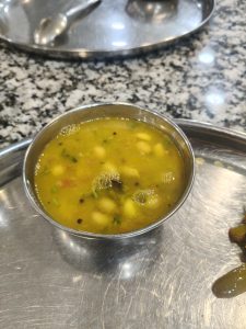 Bowl of hot vegetable soup served in a stainless steel bowl.
