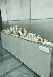 
White sculptures of people displayed in a museum.