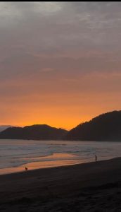 A tranquil beach scene at sunset, with soft waves lapping at the shore. 