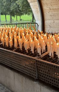 
Lit candles standing in a metal candle holder.