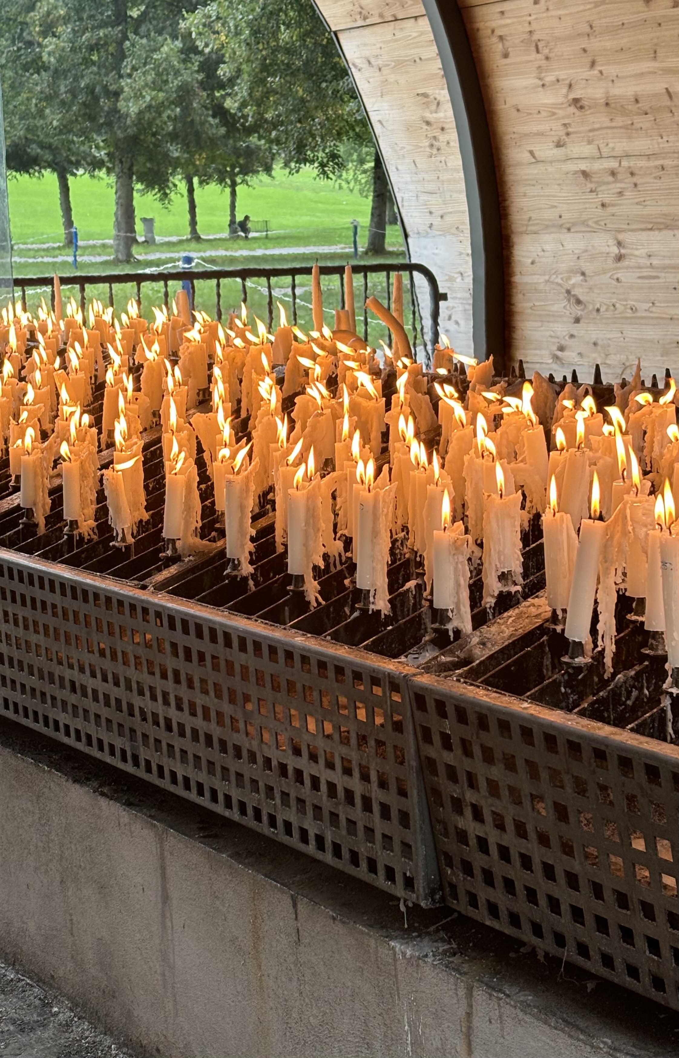 Lit candles standing in a metal candle holder.