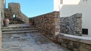 Small and ancient stone pathway, walls and stairs that leads to a stone viewpoint.