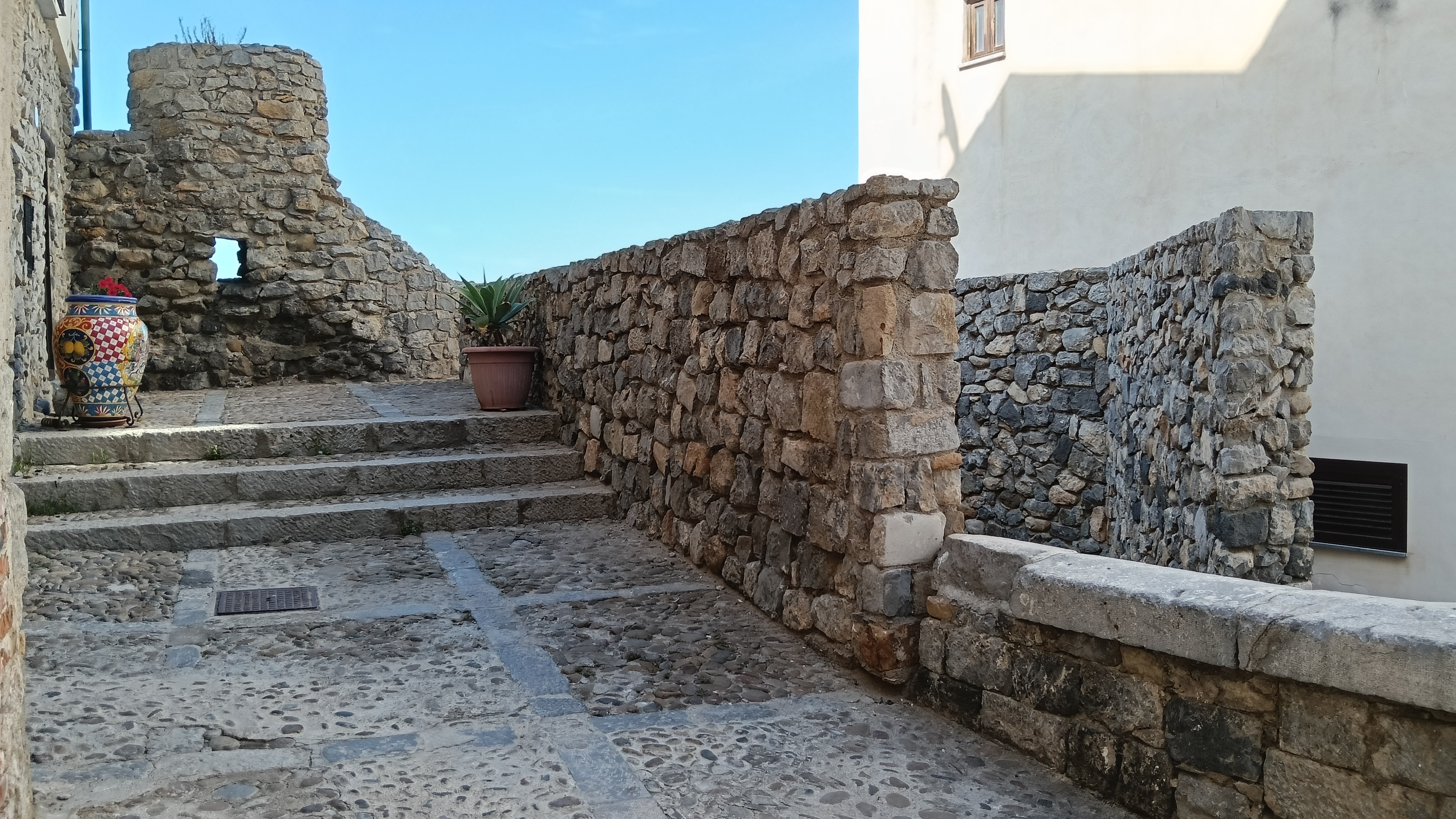 Small and ancient stone pathway, walls and stairs that leads to a stone viewpoint.