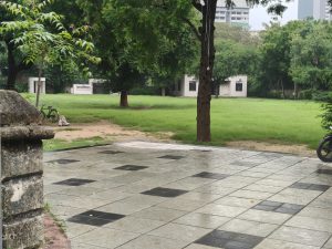 
A serene outdoor scene featuring a neatly paved area made of light gray tiles with black accents. 