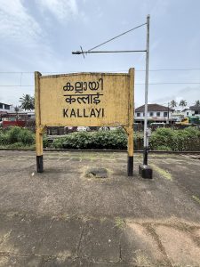 A sign that saus "Kallayi" in English, Malayalam, and Hindi/Devanagari at the Kallai railway station.