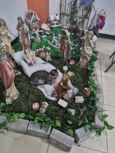 A detailed Christmas nativity scene with Jesus, Mary, Joseph, the Three Wise Men, animals, small houses, and traditional decorations.