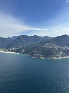 
Ocean view with mountains and a sandy beach in the background.