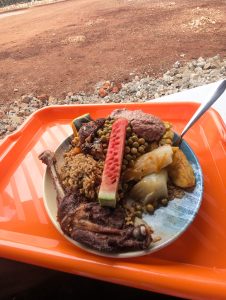A colorful plate of food sits on a bright orange tray. 
