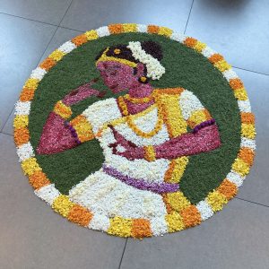 A colorful floral design depicting a classical dancer surrounded by green, white, orange, and yellow petals.