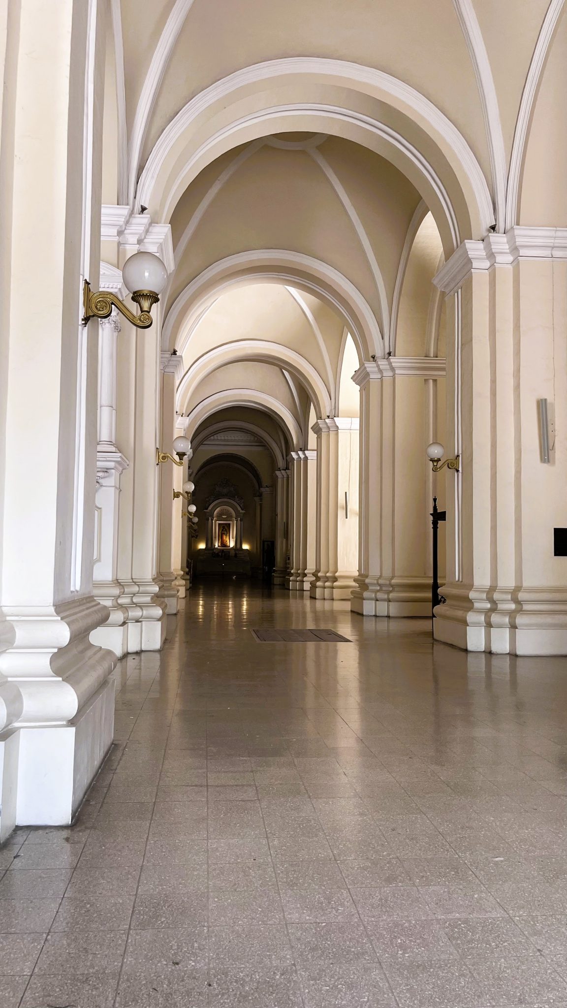 Arched interior corridor in pale stone and warm light — photo by emilycortes, WordPress Photo Directory, CC0