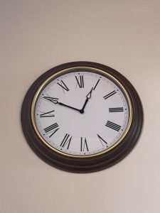 Traditional round wall clock hanging on a light-colored wall.