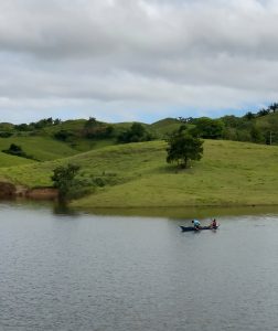 Under the open sky, two men spend their time by the water, quietly waiting for a bite.