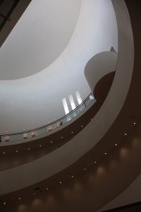 Curved balconies winding through a modern building interior.
