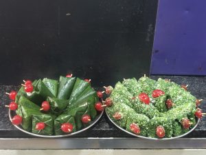 Traditional paan arranged on a stainless steel tray with red cherries.