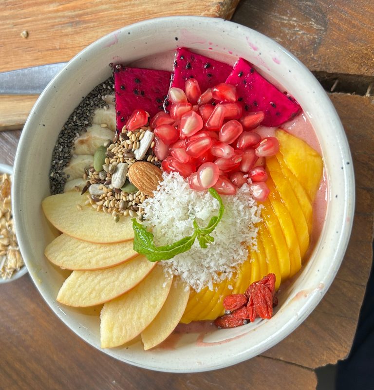 A vibrant bowl of smoothie or acai topped with a variety of fresh fruits and toppings.