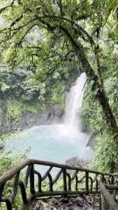 
Viewpoint overlooking a waterfall in Rio Celeste National Park surrounded by lush green forest.