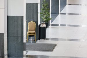 A high-angle shot featuring a chair and a dustbin placed to the side, with architectural pillars creating a leading diagonal line.