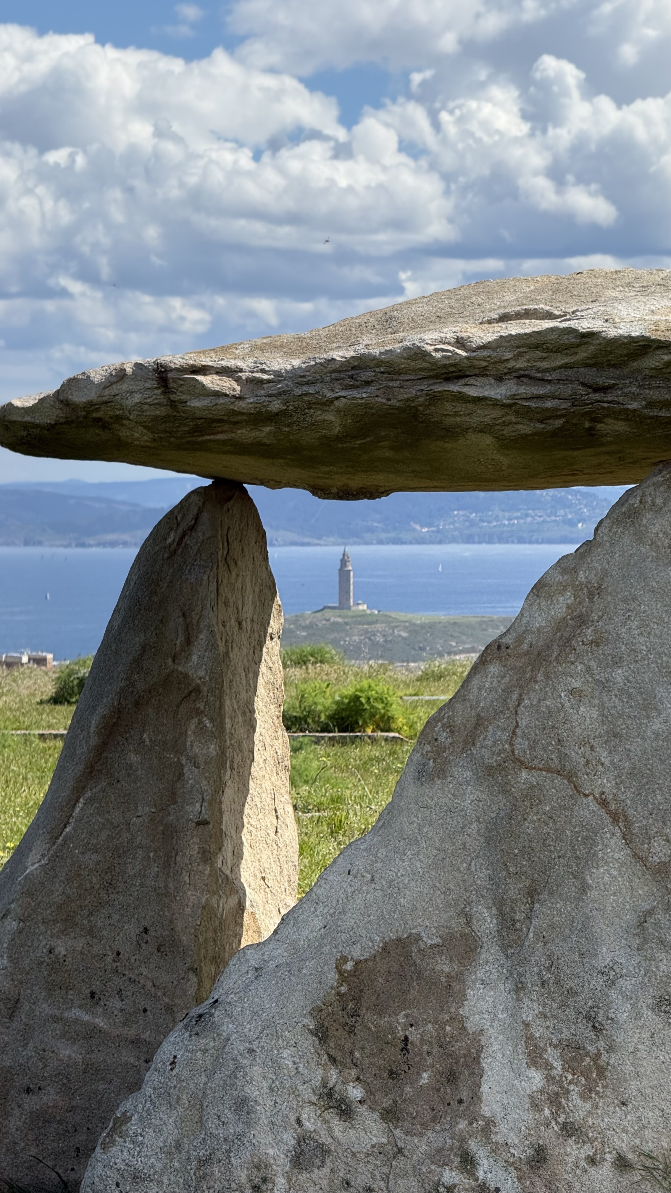 View of the sea and Tower of Hercules through a megalithic stone structure.