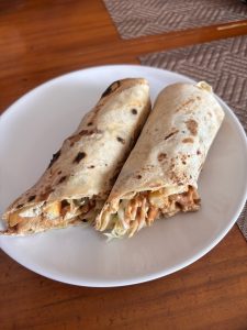 Two stuffed flatbreads are arranged side by side on a white plate.
