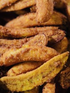 Close-up view of freshly fried golden-brown banana fritters, highlighting their crisp texture and warm colors. Location: Vallichira, Kottayam, Kerala. 