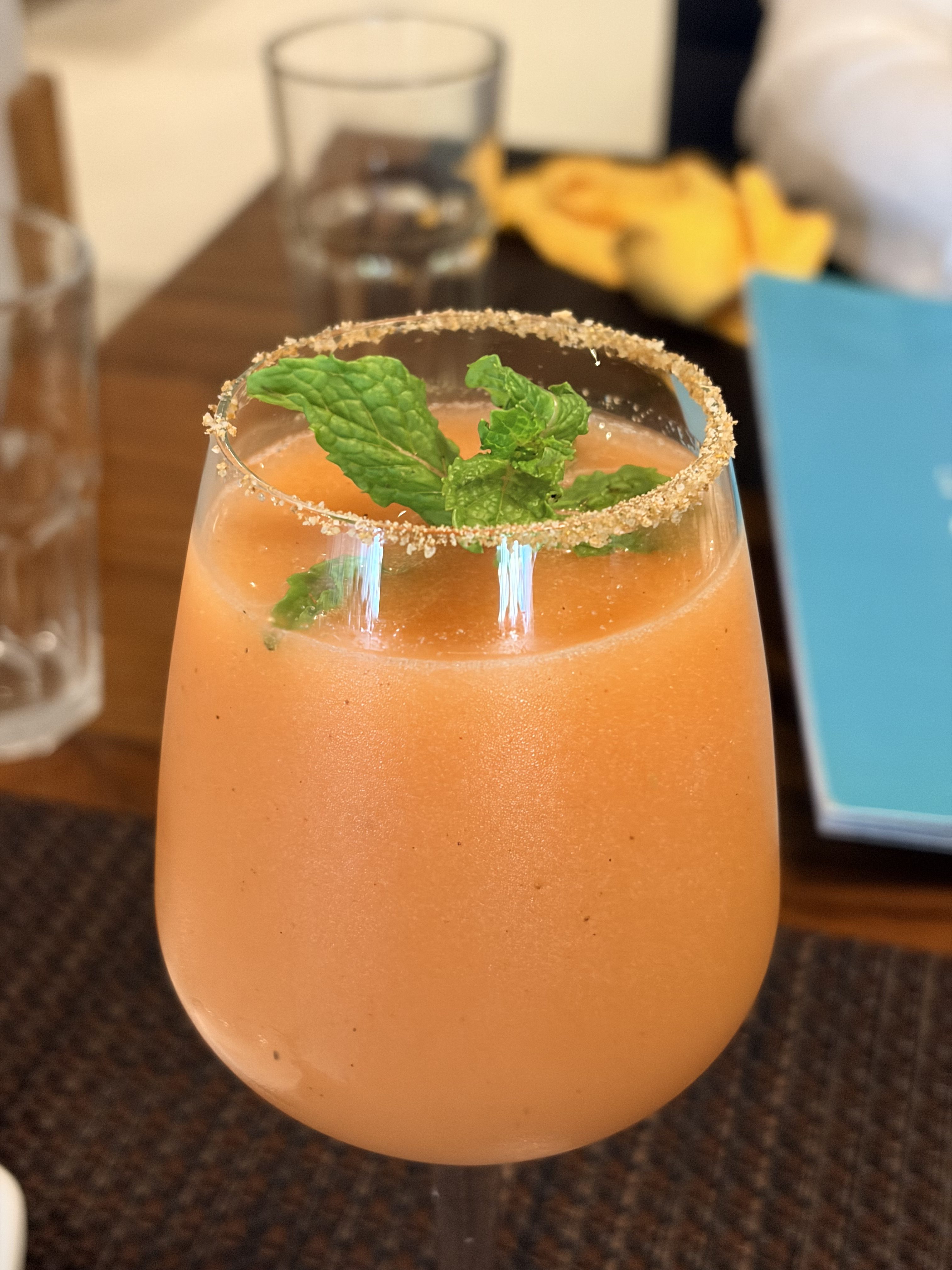 Orange mint mocktail with a salted rim and fresh mint leaves in a glass