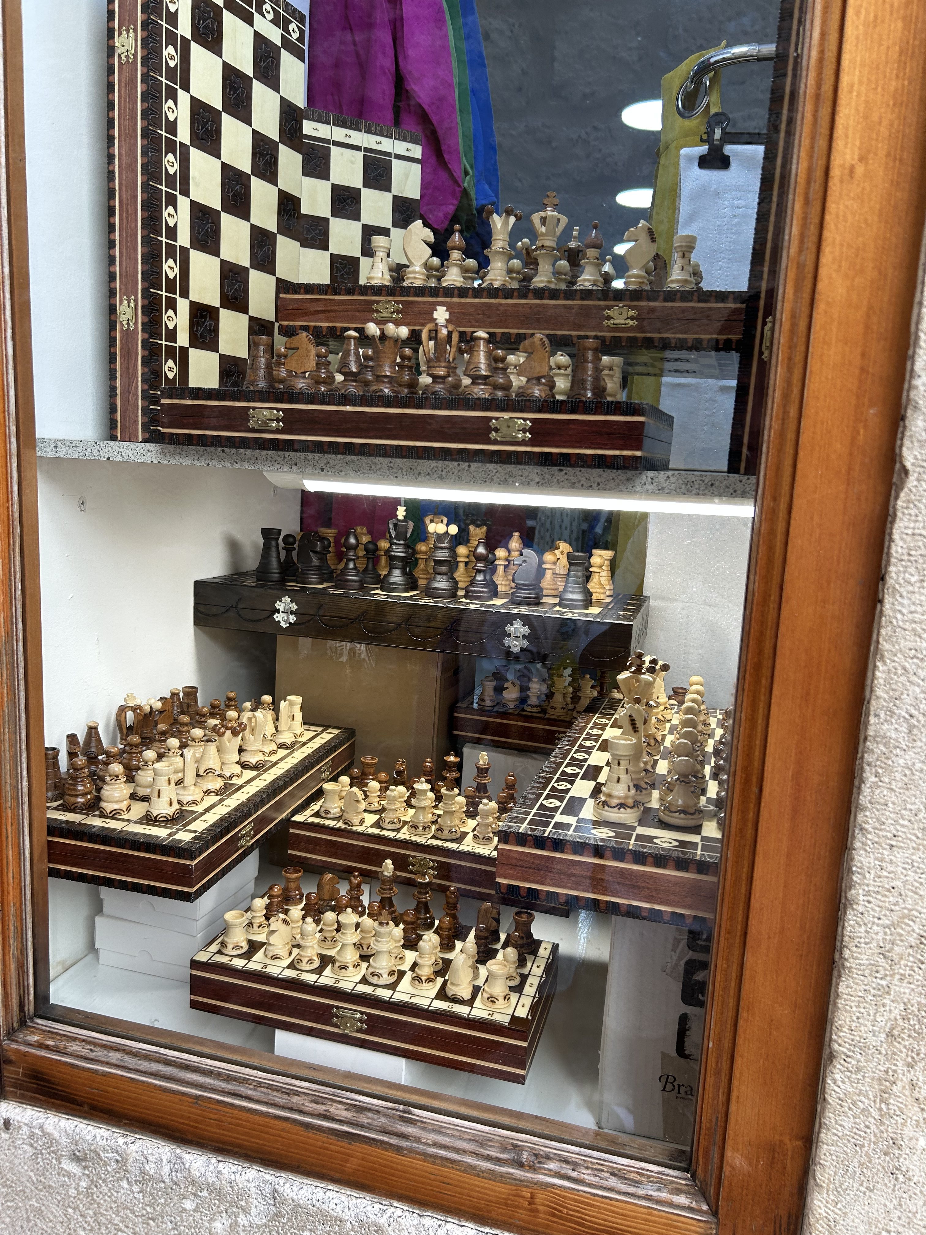 Juegos de ajedrez de madera tallada expuestos en el escaparate de una tienda