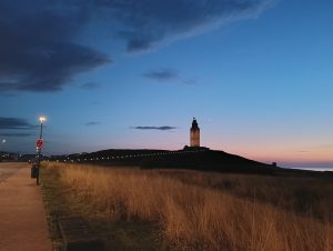 Ancient lighthouse (Hercules Tower) over the field in the sunset.