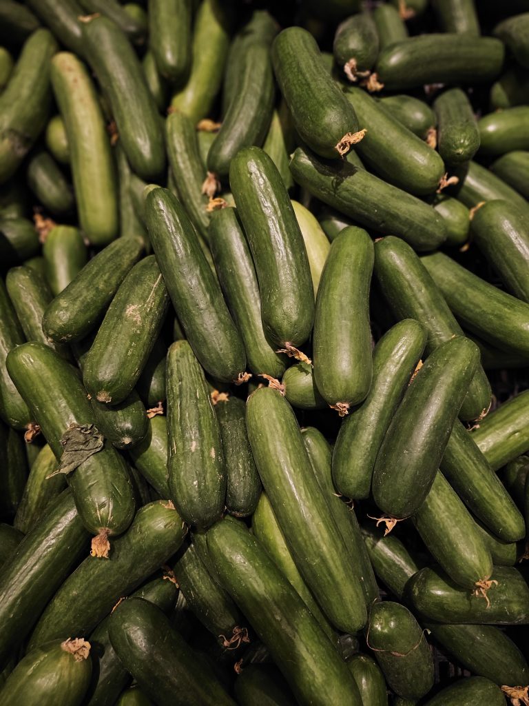 A pile of fresh green cucumbers fills the frame, creating a repetitive pattern of natural shapes, textures, and shades of green. Location: Mankavu, Kozhikode, Kerala. #wcktm2026