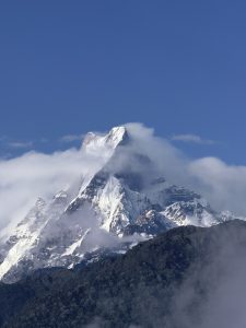 Snow-capped Machapuchare (Fish Tail) mountain peak against a clear blue sky.
