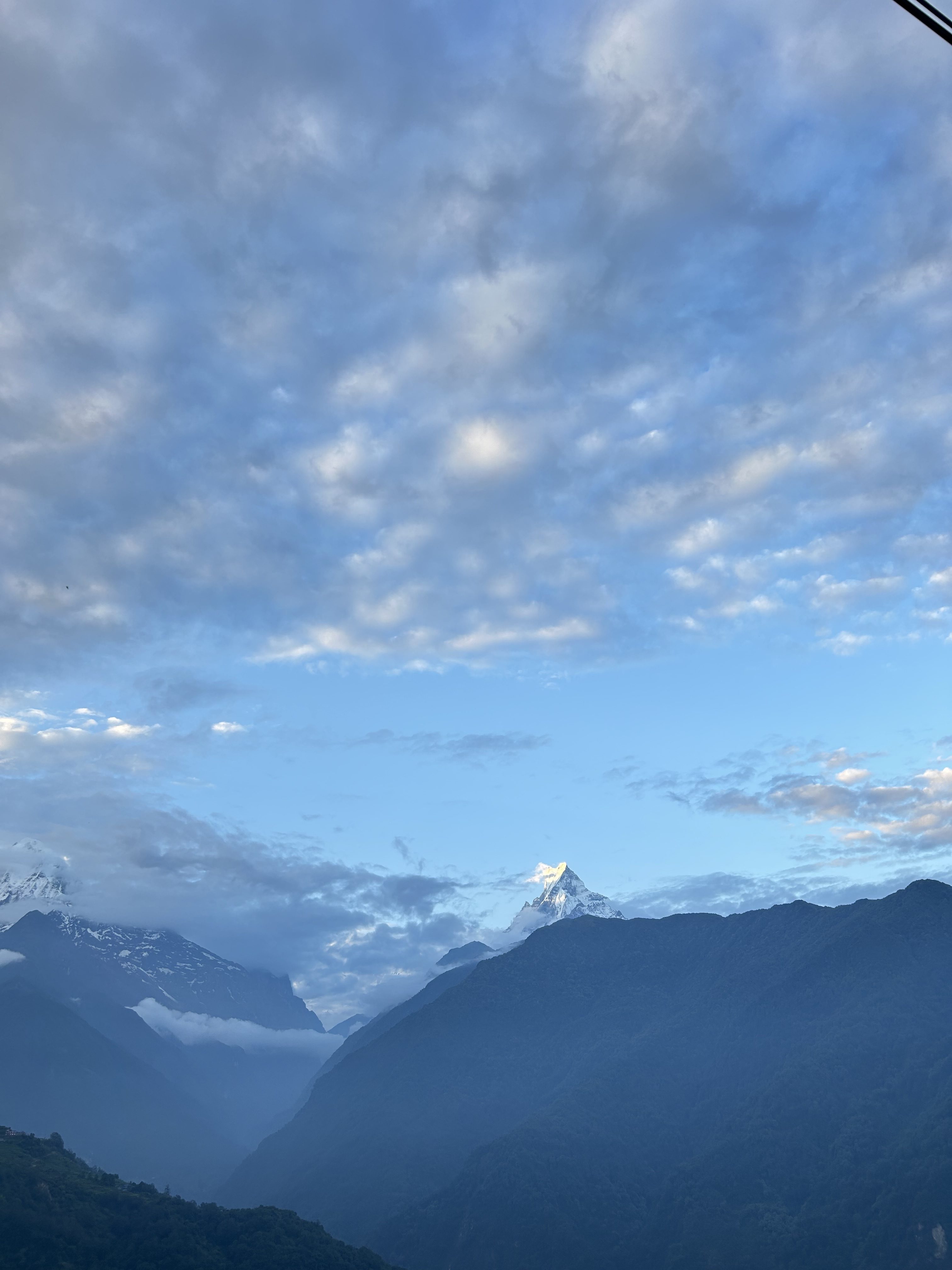 A scenic view of mountain ranges set against a vast sky.