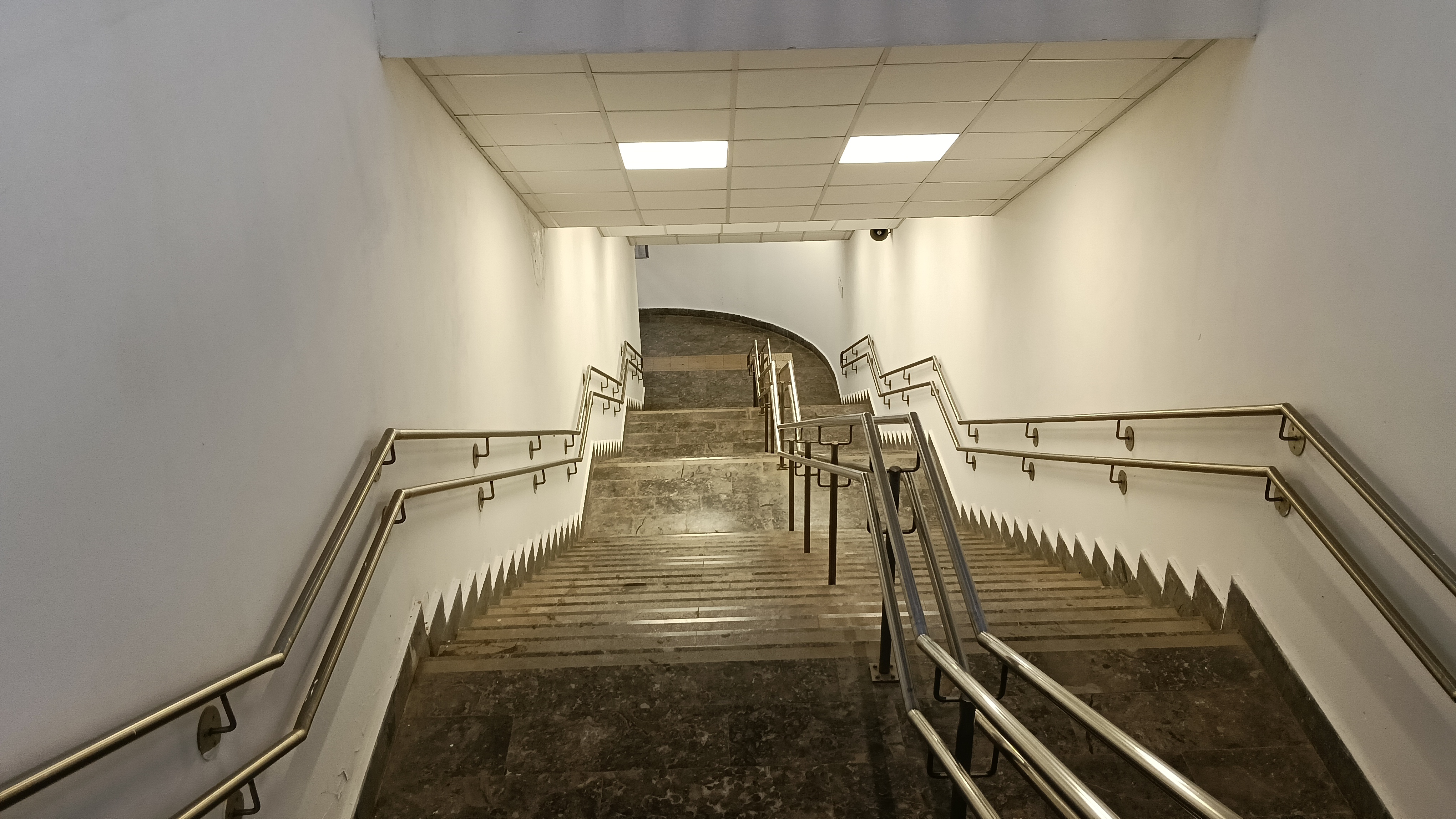 Downwards indoors staircase towards subway.