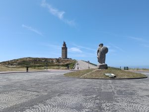 Ancient lighthouse (Hercules Tower) along an sculpture (Breogán) on a clear day.