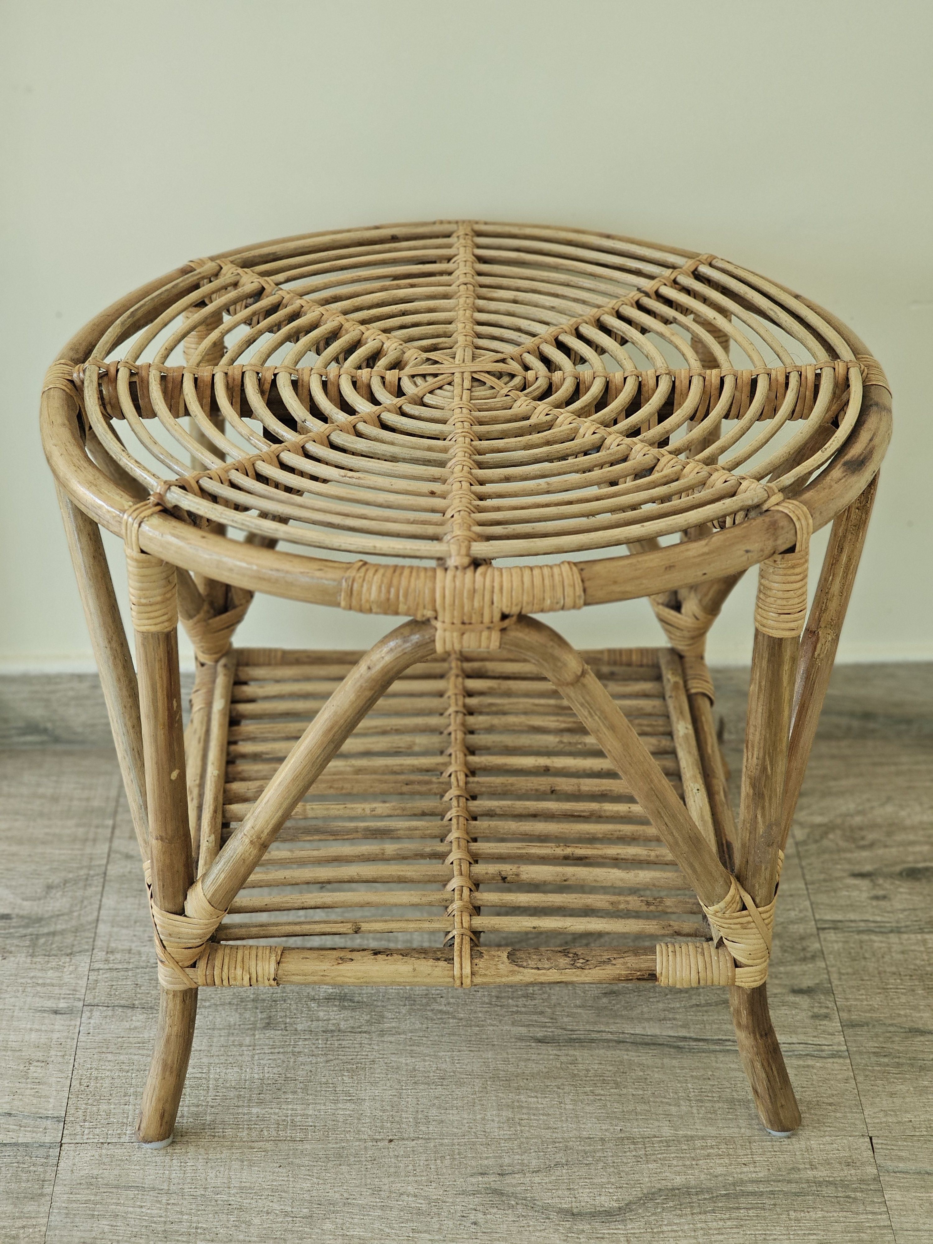 A beautifully detailed close-up of a traditional Craftcane Rattan Round Table, highlighting its circular woven top, intricate bindings, and natural bamboo texture. The symmetrical composition features a distinctive radiating spoke pattern on its tabletop. Location: Ayamkudy, Kottayam, Kerala