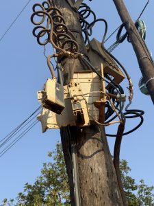 A local switch box with exposed wires and dusty taken on a sunny morning