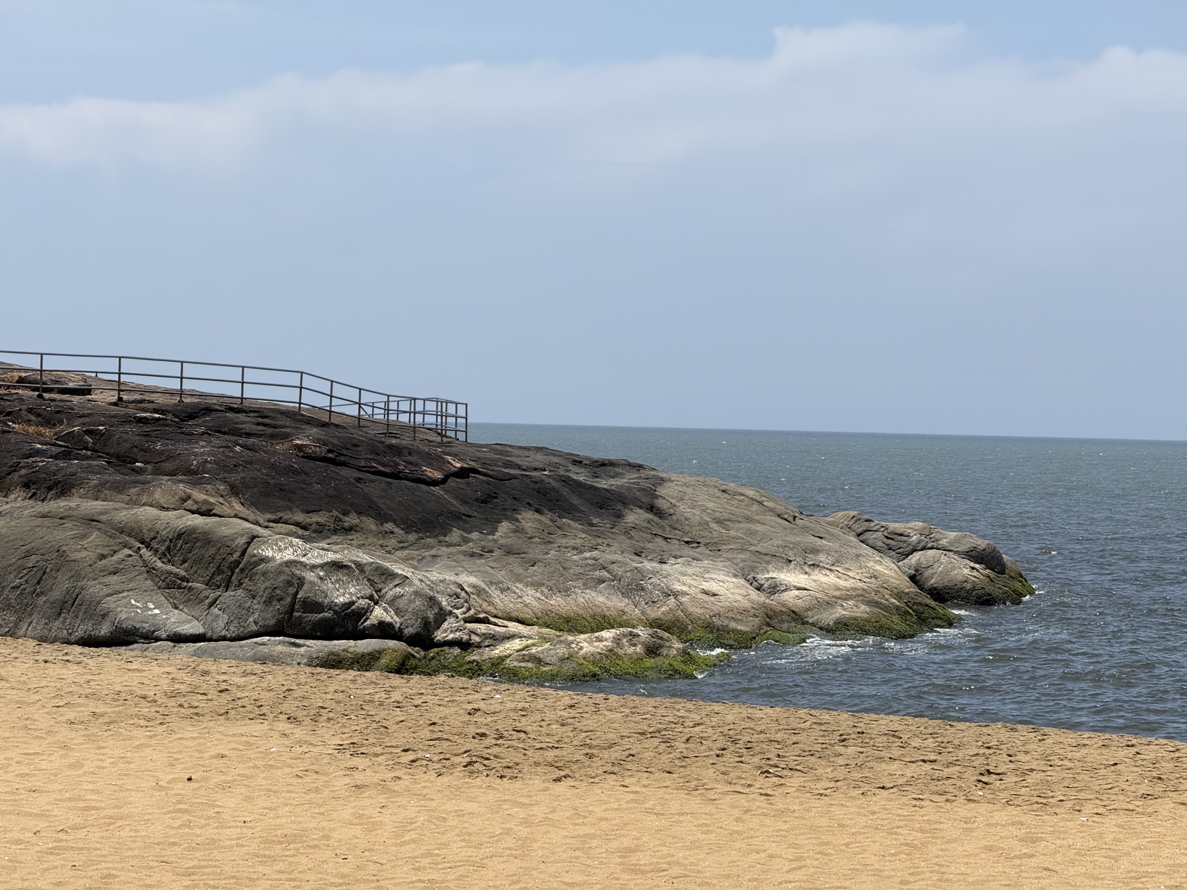 The image features a sandy beach foreground with smooth, light brown sand.