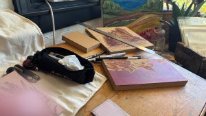 Tools for cutting wood presses, and two blocks of wood with scenes partly carved into them.