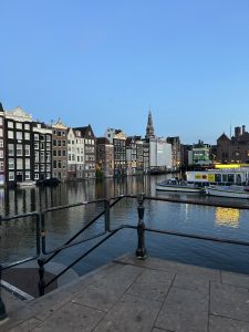 Amsterdam canals and traditional architecture reflected in the water at sunset.
