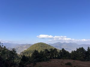 A panoramic view of a mountainous landscape under a clear blue sky. 
