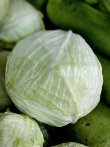 A fresh pale-green cabbage shown in close-up, with tightly layered leaves and clearly visible natural veins. The soft green tones create a clean and simple composition. Location: Kuttikkattoor, Kozhikode, Kerala.
