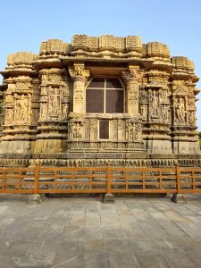 This photograph highlights the richly carved exterior wall of the Sun Temple, featuring intricate stone sculptures, decorative patterns, and traditional architectural details. Location: Sun Temple, Modhera, Mehsana district, Gujarat.
