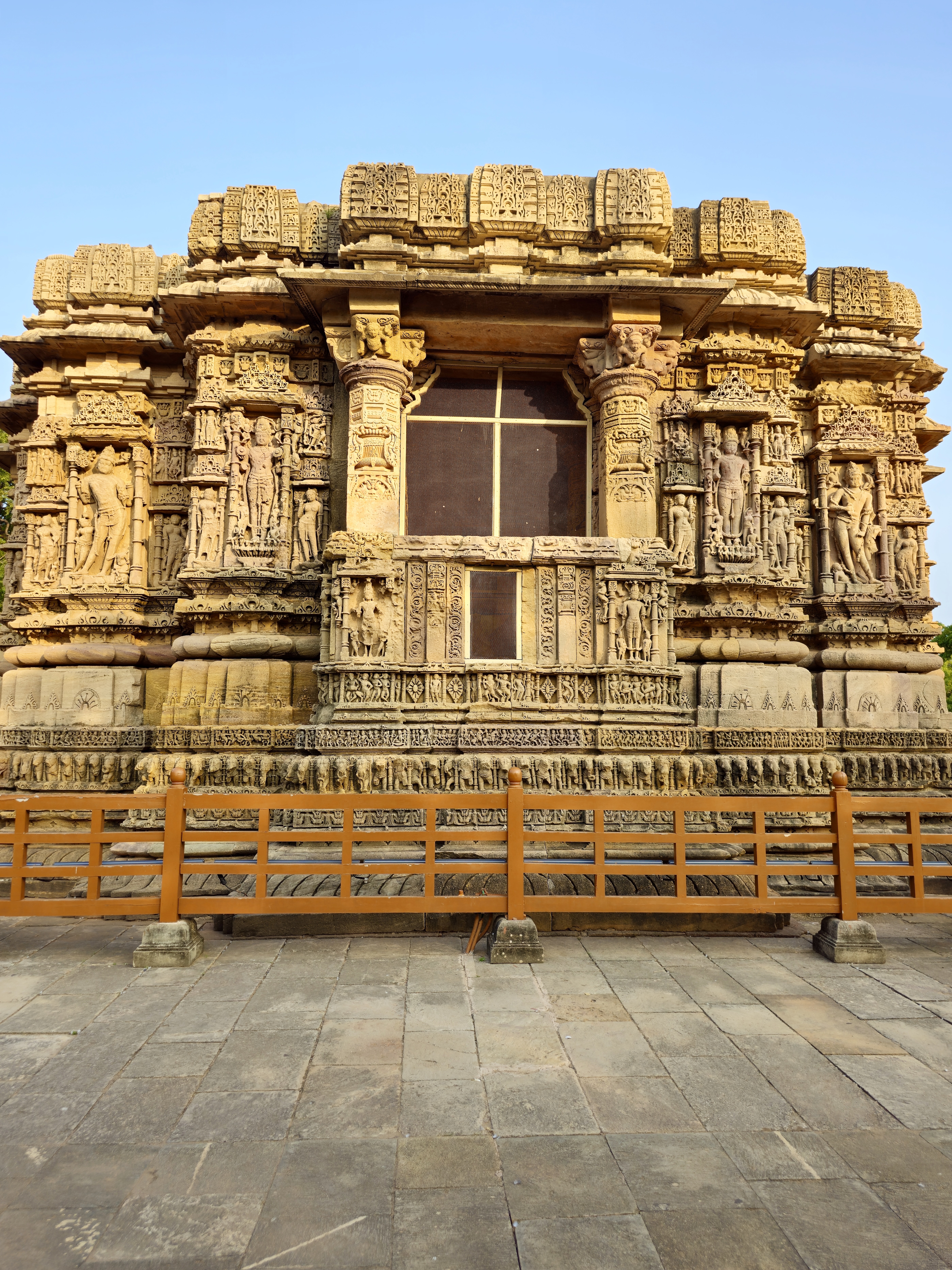 This photograph highlights the richly carved exterior wall of the Sun Temple, featuring intricate stone sculptures, decorative patterns, and traditional architectural details. Location: Sun Temple, Modhera, Mehsana district, Gujarat.