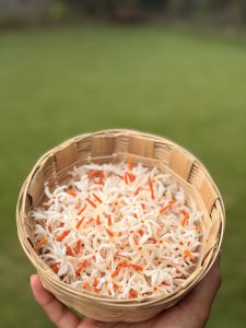 Freshly picked parijat flowers collected in a bowl with green grass background