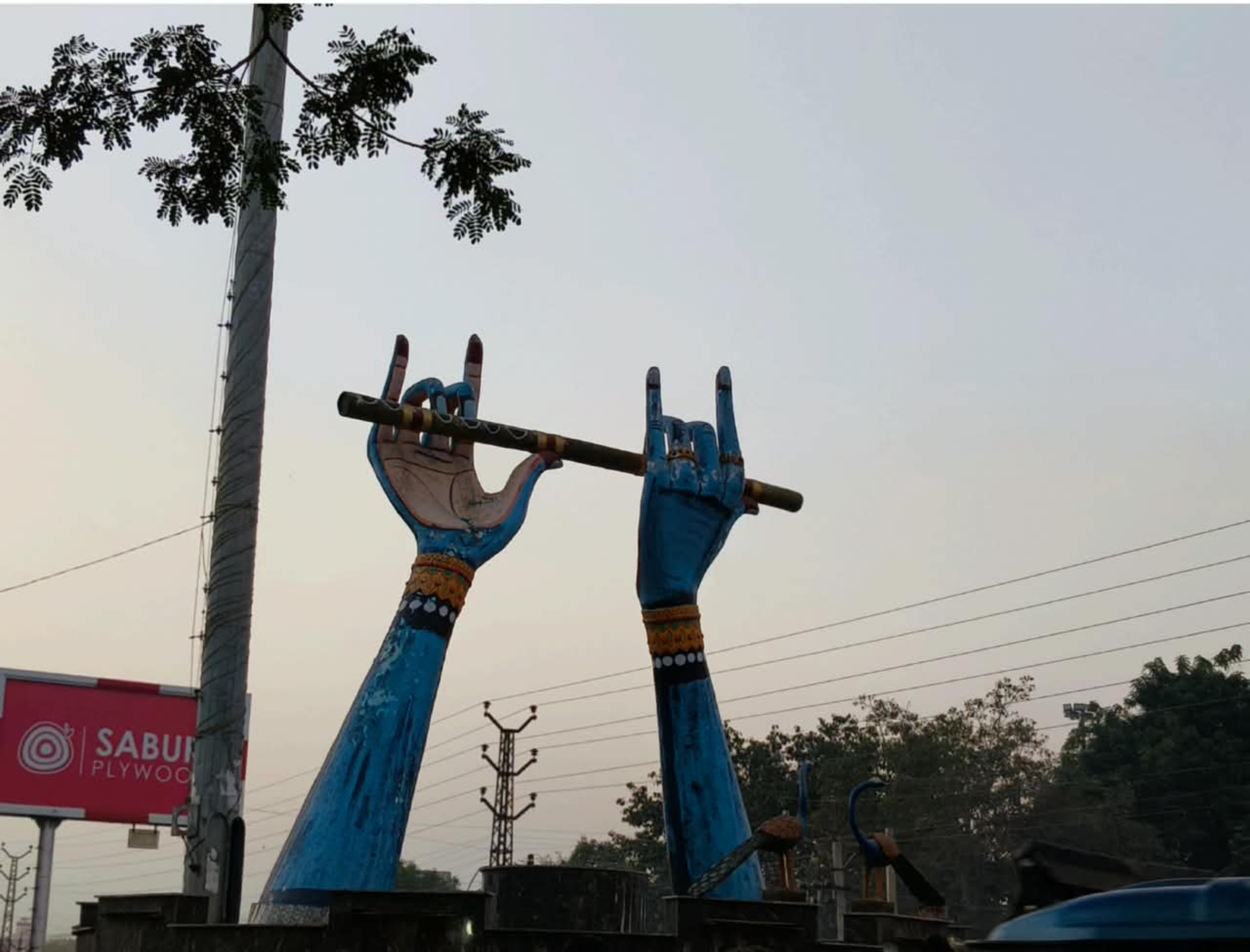 Krishna Ji hand statue in middle of the city road.