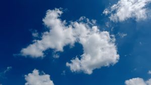 White, fluffy clouds scattered across a bright blue sky on a clear day. #
