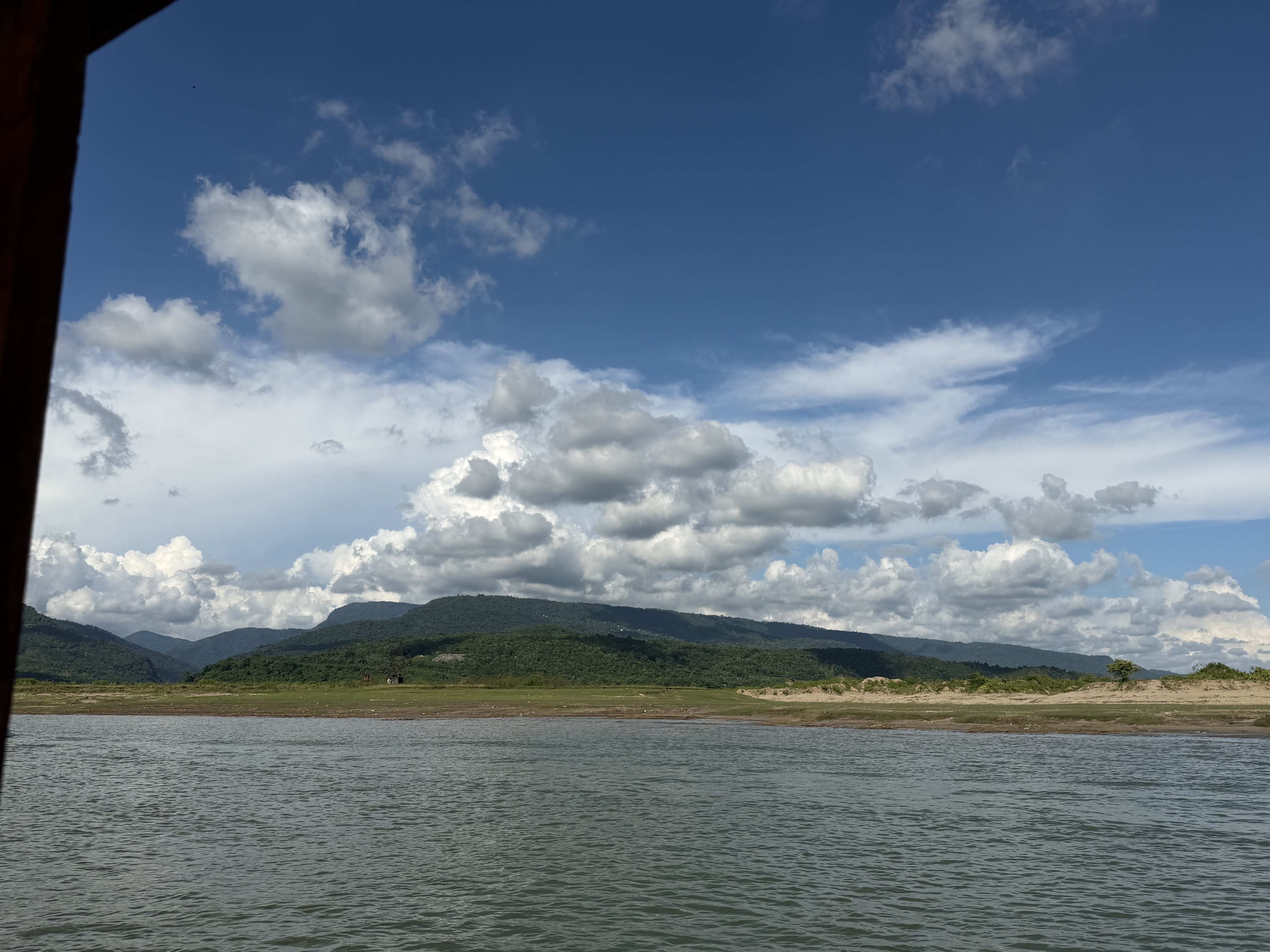 Sadapathor, Bholaganj, Sylhet, with green hills and a calm river.